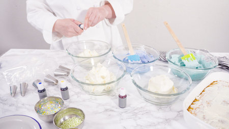 Mixing food coloring into Italian buttercream frosting.