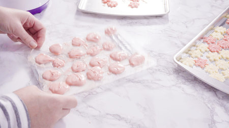 Step by step. Pouring melted chocolate into a plastic chocolate mold in the shape of snowflakes.