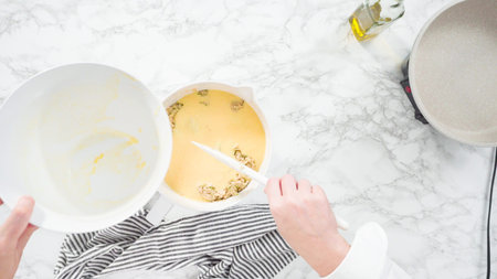 Flat lay. Step by step. Mixing ingredients in a mixing bowl to make zucchini cakes.