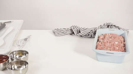 Step by step. Mixing ingredients for a classic beef meatloaf recipe in a glass mixing bowl.の写真素材