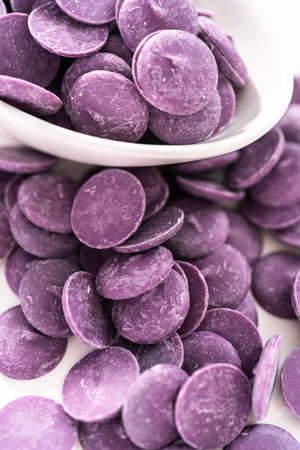 Purple round chocolate chips for melting chocolate shapes on a white background.の写真素材