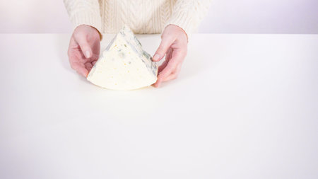 Large slice of gourmet cheese on a white background.