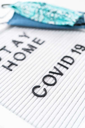 STAY HOME and COVID-19 sign on message board with a homemade face mask.の写真素材