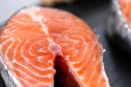 Farm-raised salmon steaks on a slate board.の写真素材