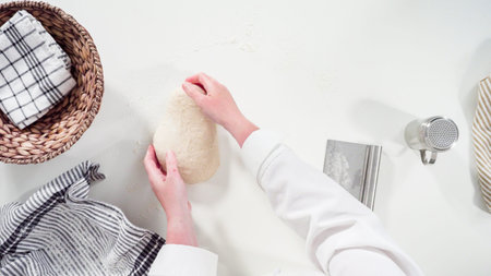 Flat lay. Knitting dough by hand to bake cinnamon rolls.