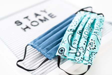 STAY HOME sign on message board with a homemade face mask.