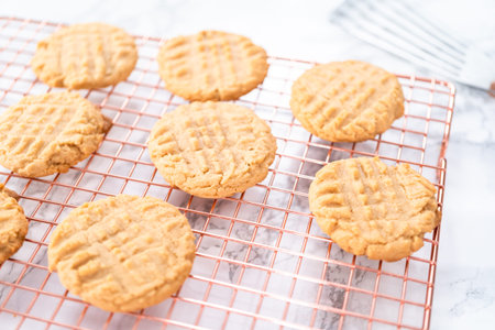 Freshly baked peanut butter cookies cooling on a drying rack.