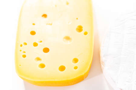 Large slice of semi soft part skim cheese on a white background.の写真素材