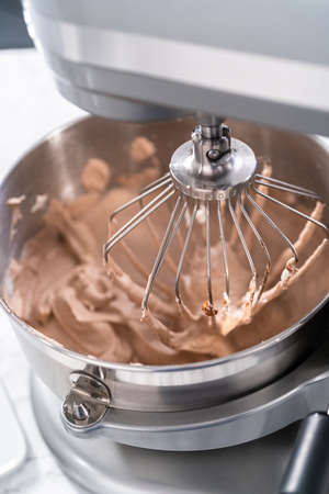 Mixing ingredients in a standing kitchen mixer to make homemade chocolate ice cream.の写真素材