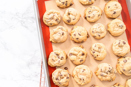 Freshly baked homemade soft chocolate chip cookies on a baking sheet.