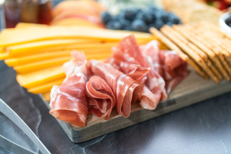 Gourmet cheese, crackers, and fruit on a wood cutting board served as an appetizer.