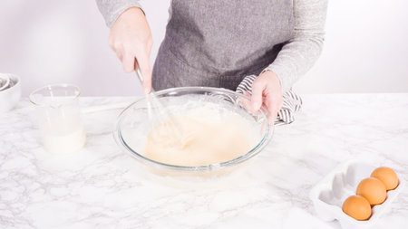 Mixing ingredient in a glass mixing bowl to make the crepes batter.
