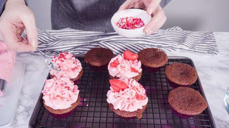Step by step. Decorating red velvet cupcakes with chocolate red hearts and kisses.の写真素材
