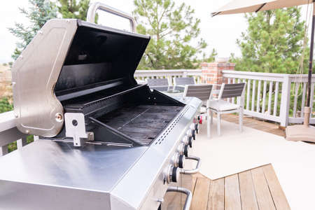 Outdoor six-burner gas grill on the back patio of a luxury single-family home.の写真素材