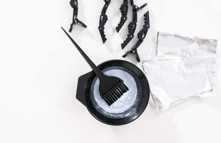 Flat lay. Hair color dye powder in a black plastic mixing bowl on a white background.の写真素材