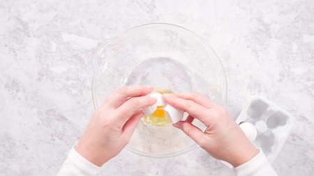 Flat lay. Step by step. Mixing ingredients in a glass mixing bowl to prepare red velvet bundt cake.の写真素材