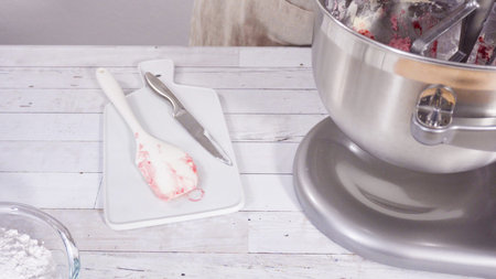 Preparing raspberry cream cheese buttercream in kitchen mixer for bake chocolate raspberry cupcakes.