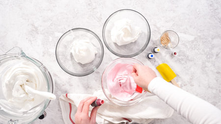 Flat lay. Step by step. Mixing in food coloring into the meringue to bake unicorn meringue pops...