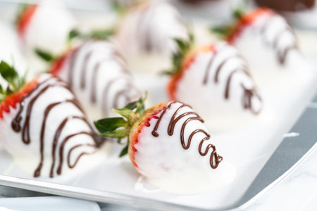 Organic strawberries dipped in chocolate drying on a parchment paper.の写真素材