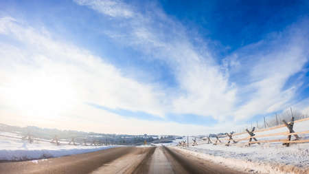 Driving on a rural road in American suburbs on Winter morning.の写真素材