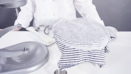 Mixing ingredients in a kitchen standing mixer to bake cinnamon rolls.