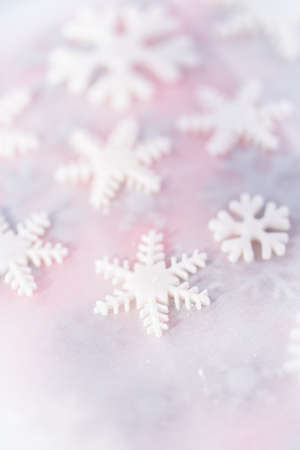 Snowflake shapes cutouts out of fondant on a parchment paper.の写真素材