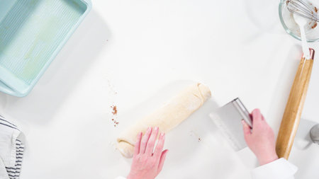 Flat lay. Rolling dough with a french rolling pin to bake cinnamon rolls.