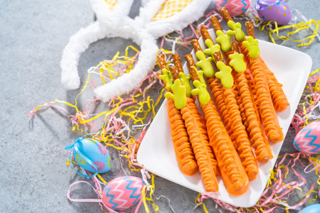 Carrot chocolate-covered pretzels on a white serving plate for the Easter table.