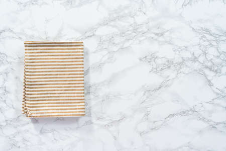 Flat lay. Kitchen towels with white and beige stripes on the marble counter.の写真素材