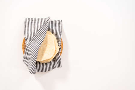 Flat lay. Stack of freshly baked flatbread wrapped in a kitchen towel.の写真素材