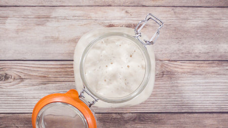 Flat lay. Baking homemade sourdough wheat bread in cast iron dutch oven.の写真素材