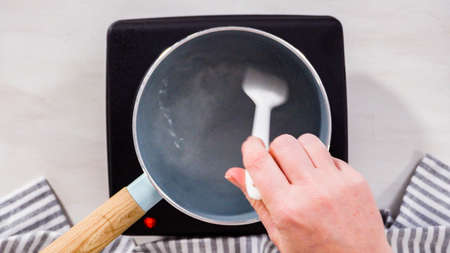 Step by step. Flat lay. Preparing sugar syrup in a small saucepan over an electric pan.の写真素材