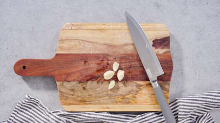 Cutting organic garlic on a wood cutting board.の写真素材