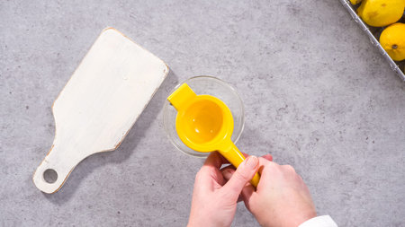 Flat lay. Step by step. Squeezing fresh lemons for baking lemon cranberry bundt cake.