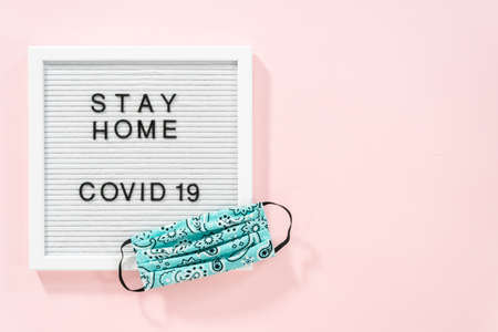 STAY HOME and COVID-19 sign on message board with a homemade face mask.の写真素材