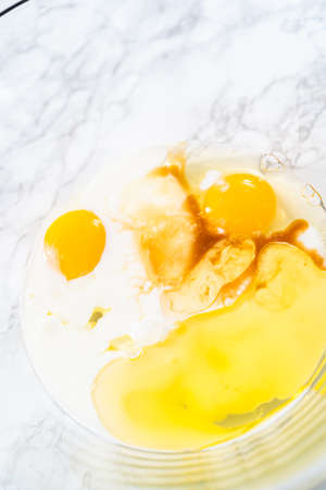 Mixing ingredients in a glass mixing bowl to bake a chocolate cupcake.の写真素材