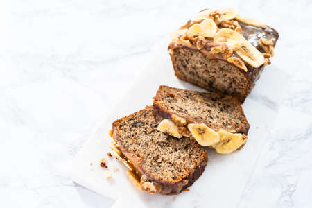 Sliced banana nut bread with drizzled with homemade caramel on a marble cutting board.の写真素材