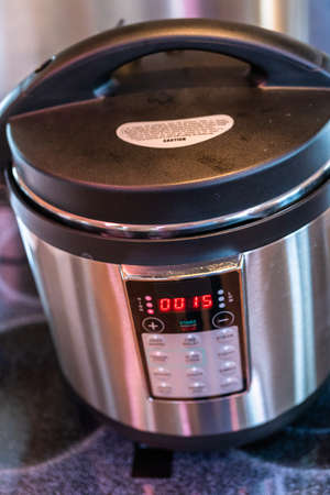 Cooking dinner in a pressure cooker in a modern kitchen.の写真素材