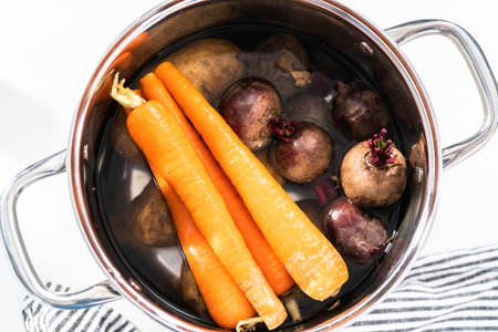 Boiling vegetables in a big cooking pot to make a vinaigrette salad.の写真素材