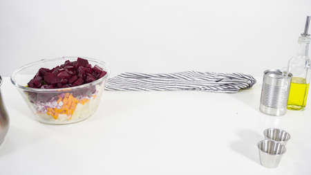 Step by step. Mixing ingredients in the glass mixing bowl to make a vinaigrette salad.の写真素材