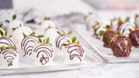 Step by step. Dipping organic strawberries into a bowl with melted chocolate to prepare chocolate covered strawberries.の写真素材