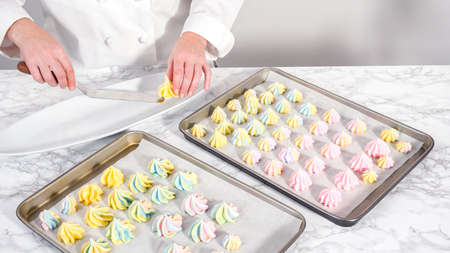 Step by step. Freshly baked unicorn meringue cookies on a baking sheet with a parchment paper.の写真素材