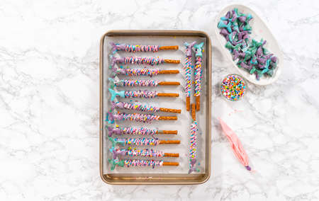 Mermaid chocolate pretzel rods drizzled with pink and purple chocolate and covered with sprinkles.の写真素材