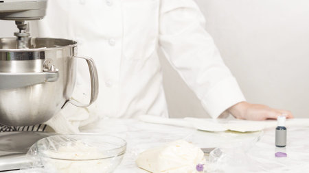 Mixing ingredients in standing kitchen mixer to make buttercream frosting.