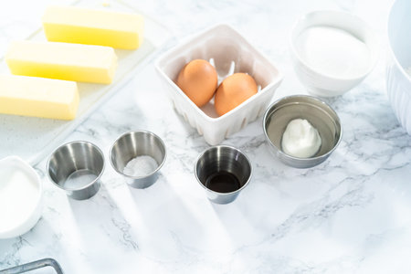 Ingredients for baking vanilla cupcakes on a marble countertop.の写真素材