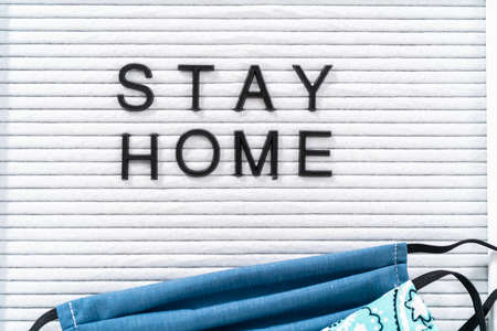 STAY HOME sign on message board with a homemade face mask.の写真素材