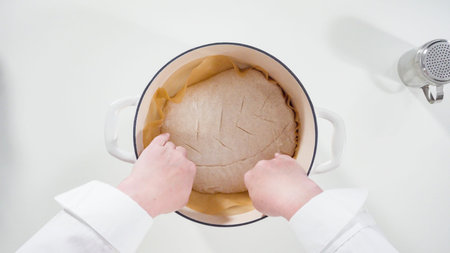 Baking homemade sourdough wheat bread in cast iron dutch oven.