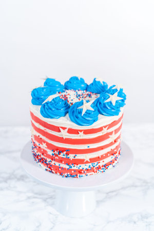 Decorating chocolate cake with white, red, and blue buttercream frosting for July 4th celebration.