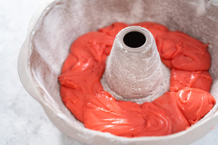 Filling bundt cake pan with red, white, and blue cake dought to bake July 4th bundt cake with...