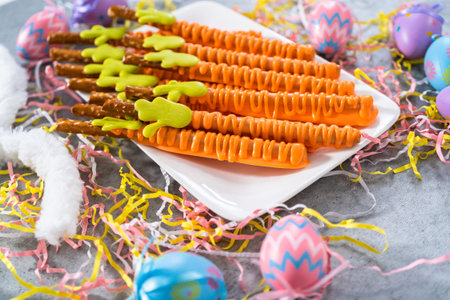 Carrot chocolate-covered pretzels on a white serving plate for the Easter table.